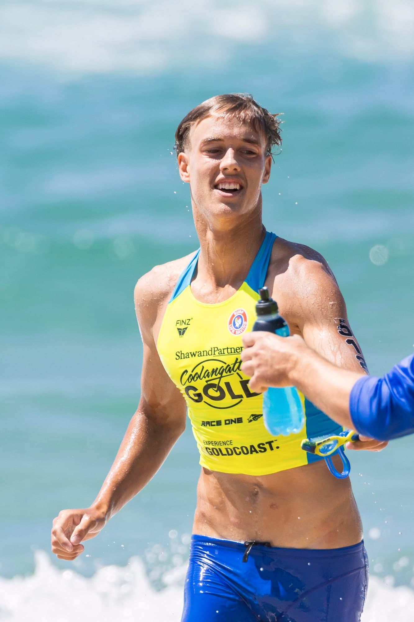 Atleta del Coolangatta Gold hidratándose en la playa